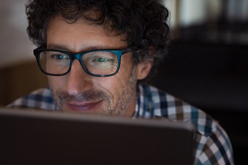 Mann mit Brille am Computer