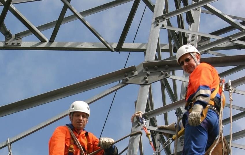 Männer auf Strommast