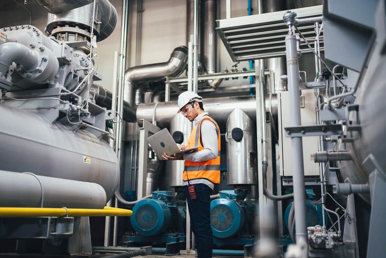 Technician with laptop in the factory
